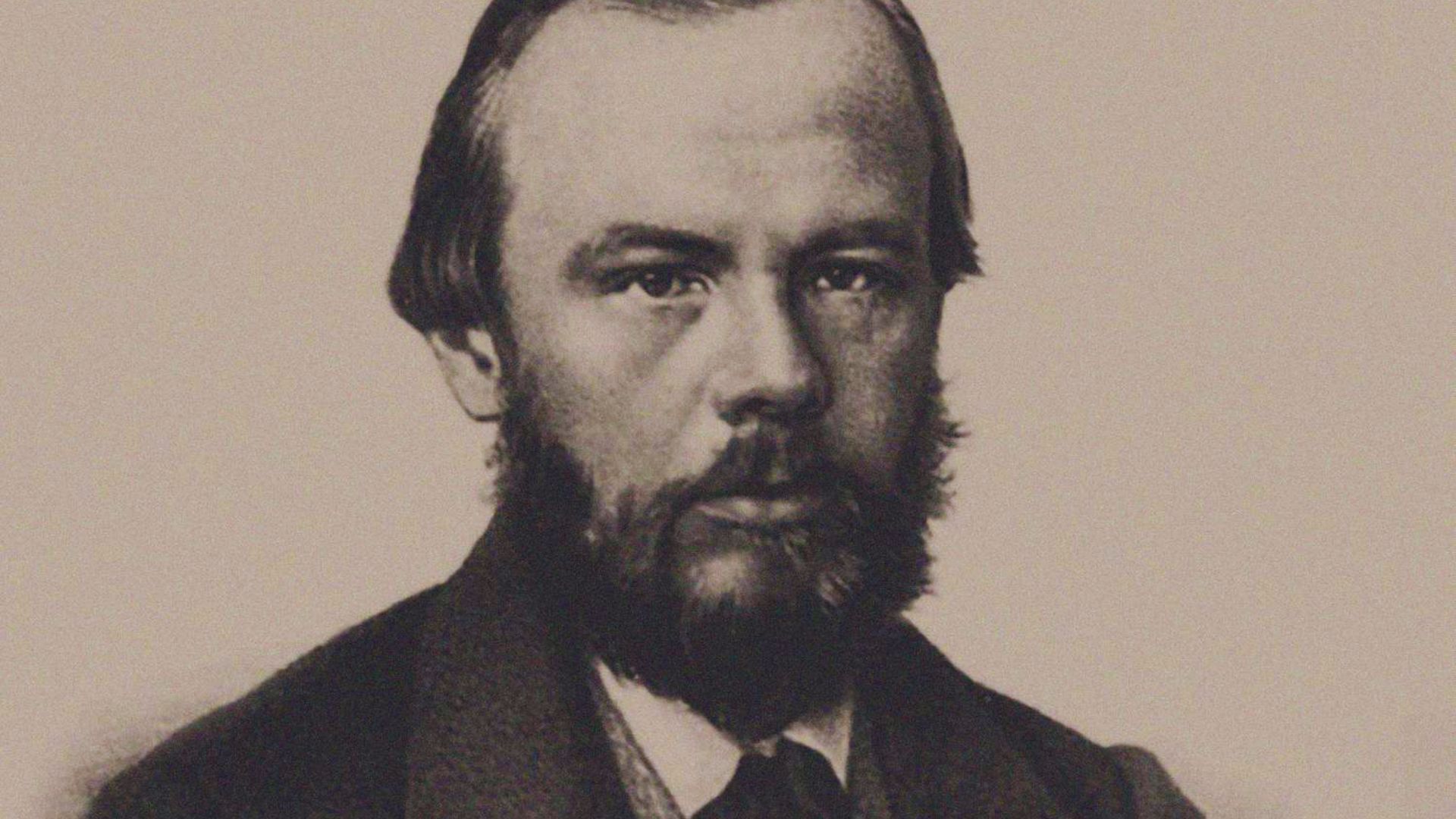 A black and white portrait of a bearded man, showcasing his facial features and expression.