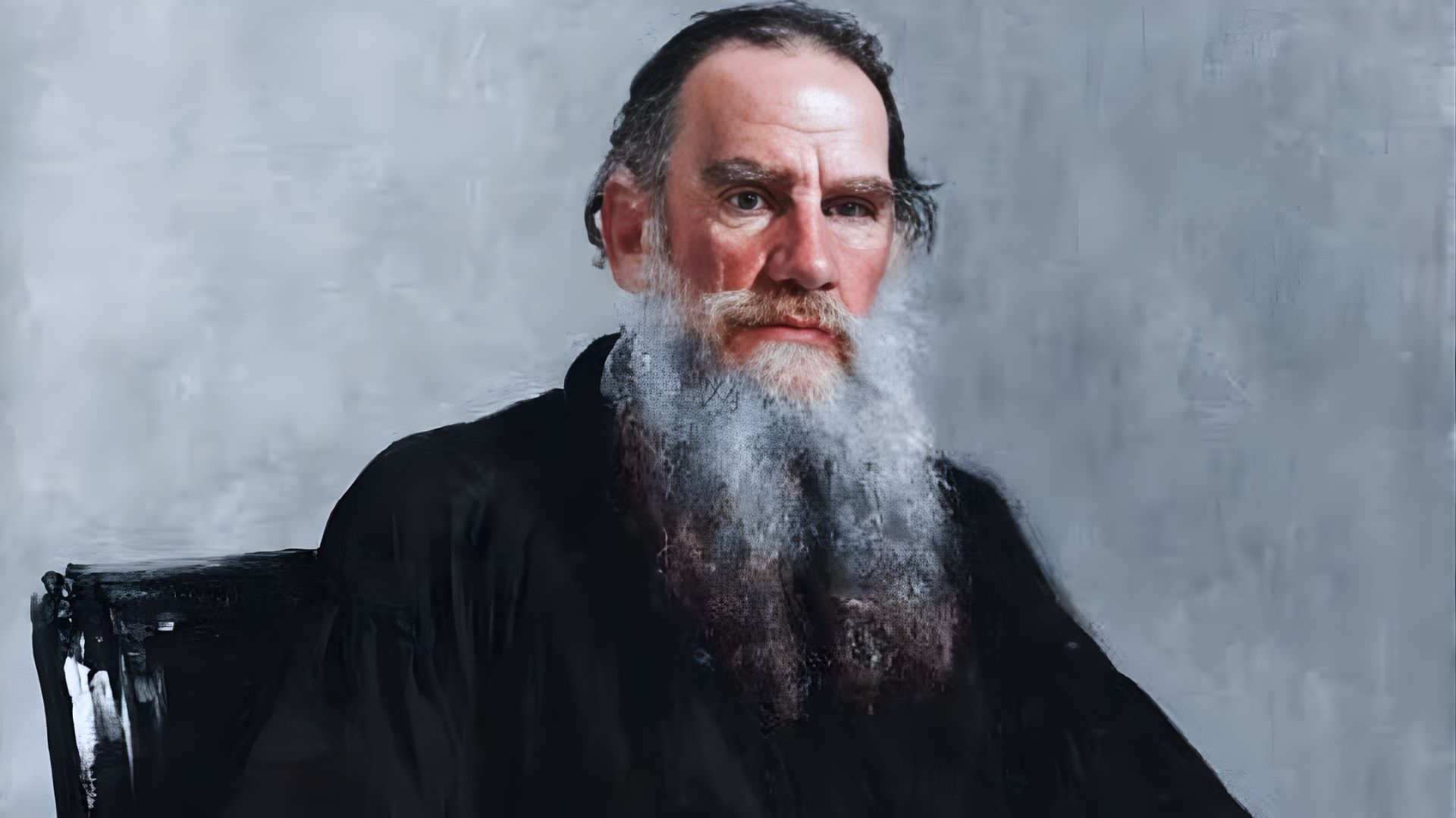 Portrait of an older man with a long white beard and serious expression, seated against a plain gray background, wearing a dark, formal robe. The tone is solemn.