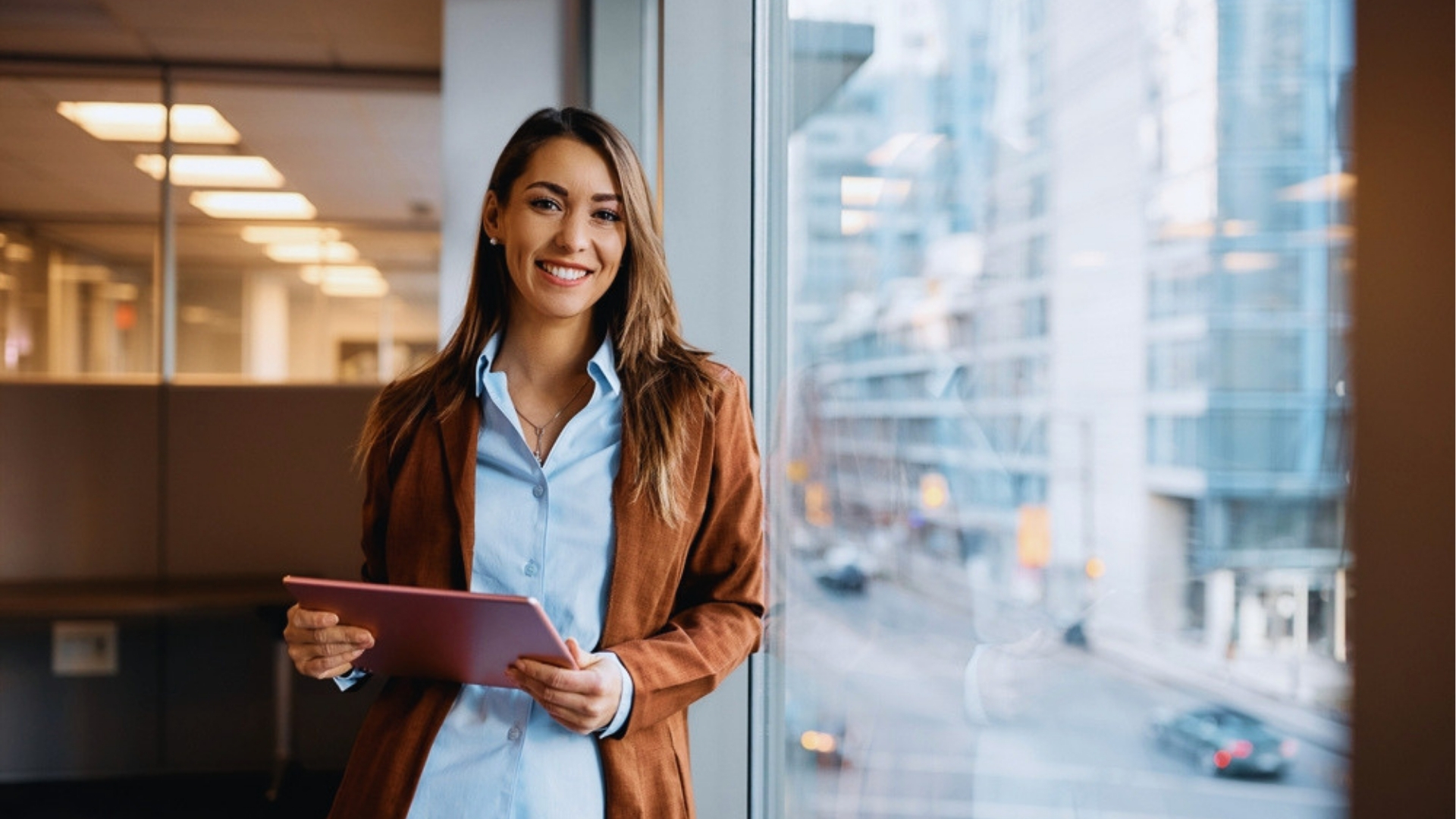 Professional standing near office window holding tablet, overlooking city street with modern buildings.</p>
<p>Picking the right course saves time and gets you better results faster.