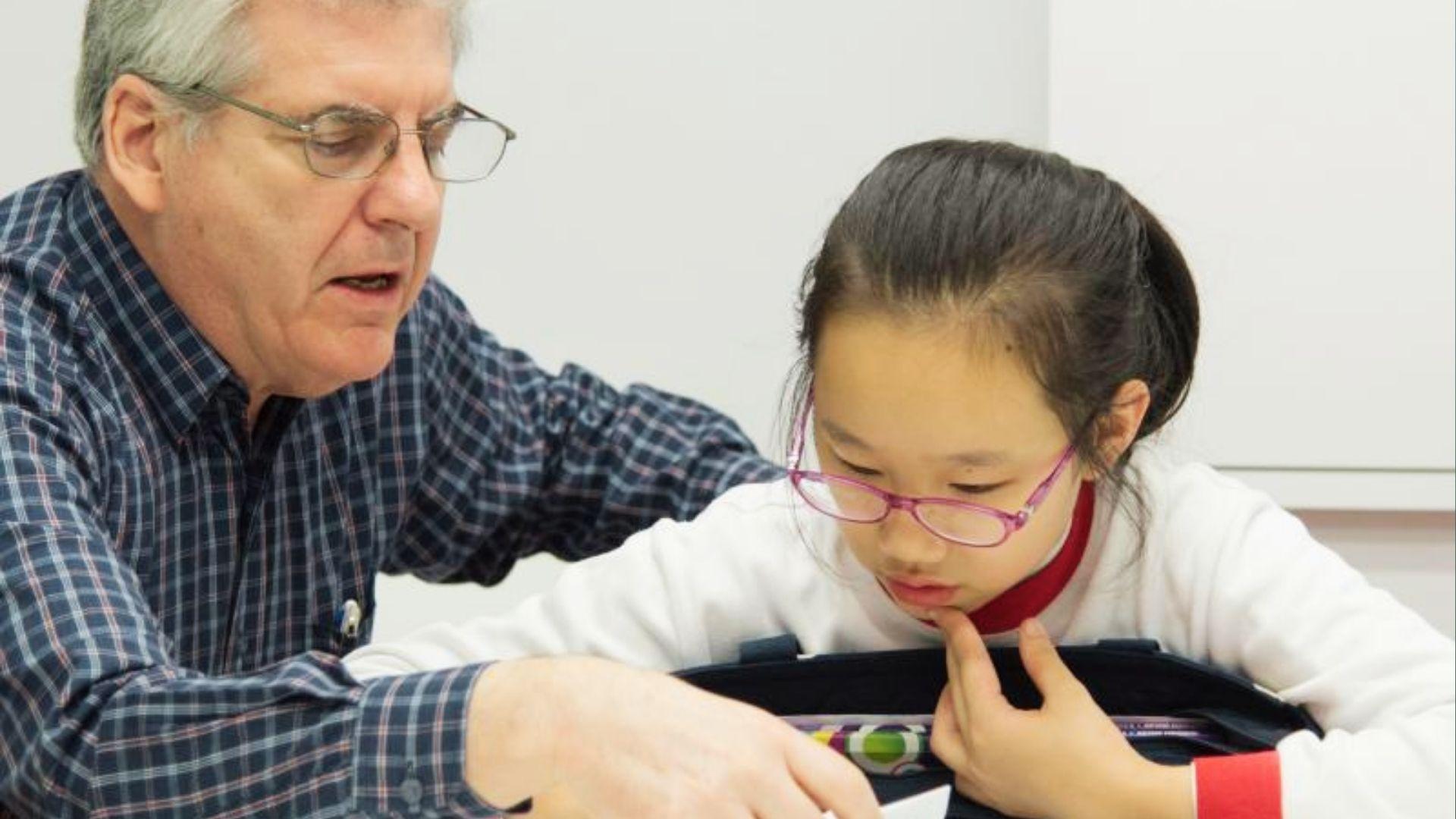 Teacher helping middle school girl with schoolwork, showing the value of asking for help early.