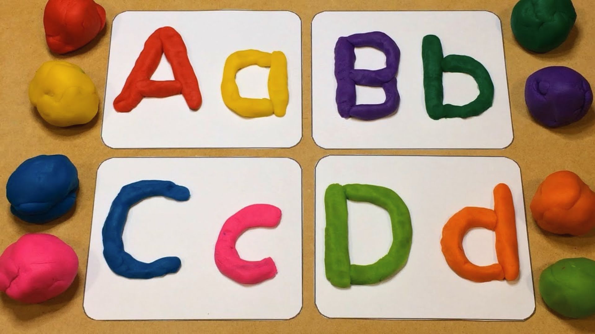 Uppercase and lowercase letters A to D are shaped from bright playdough on alphabet cards.