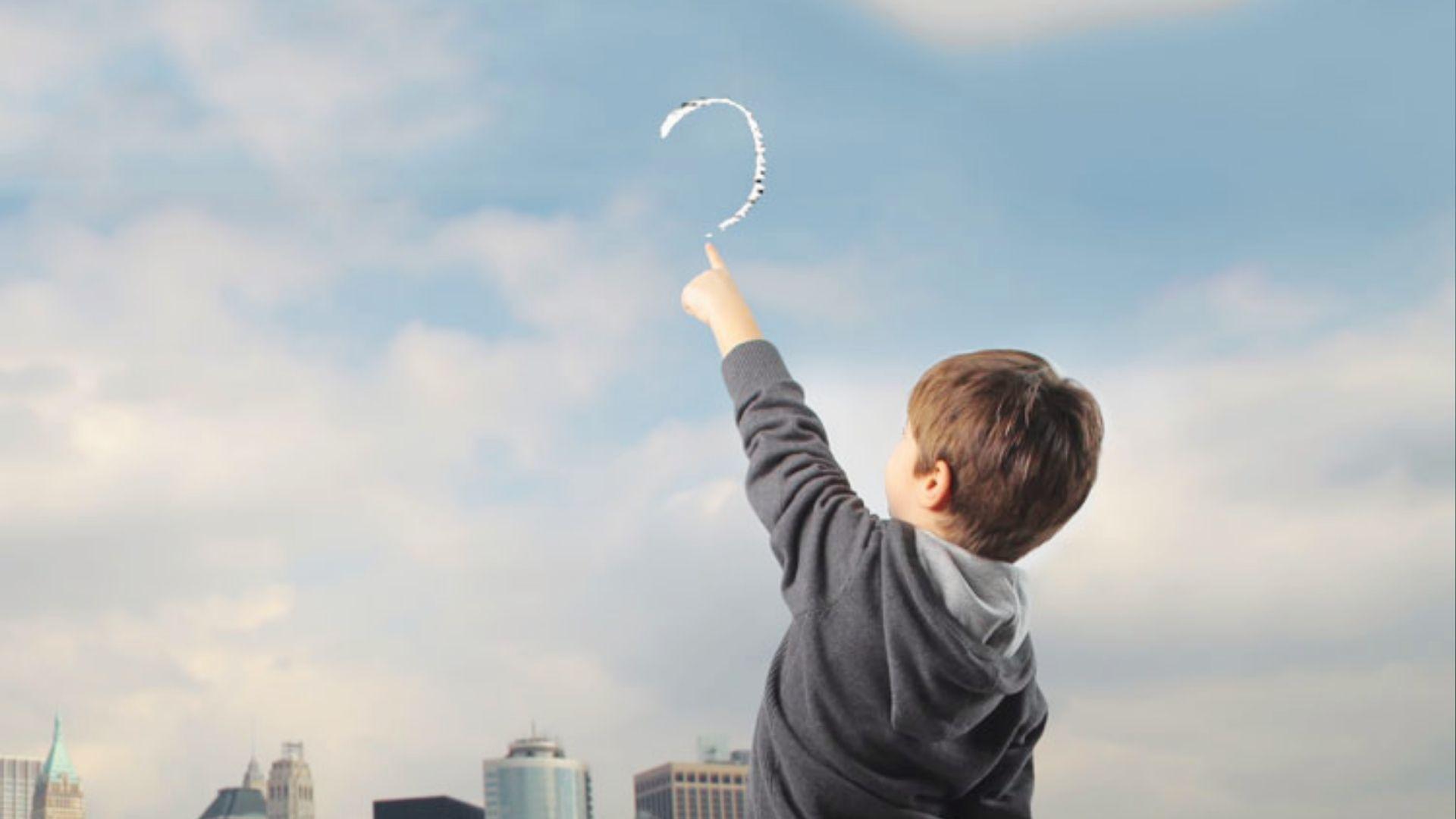 Boy points to draw a question mark in sky, sparking curiosity for creative spelling word games