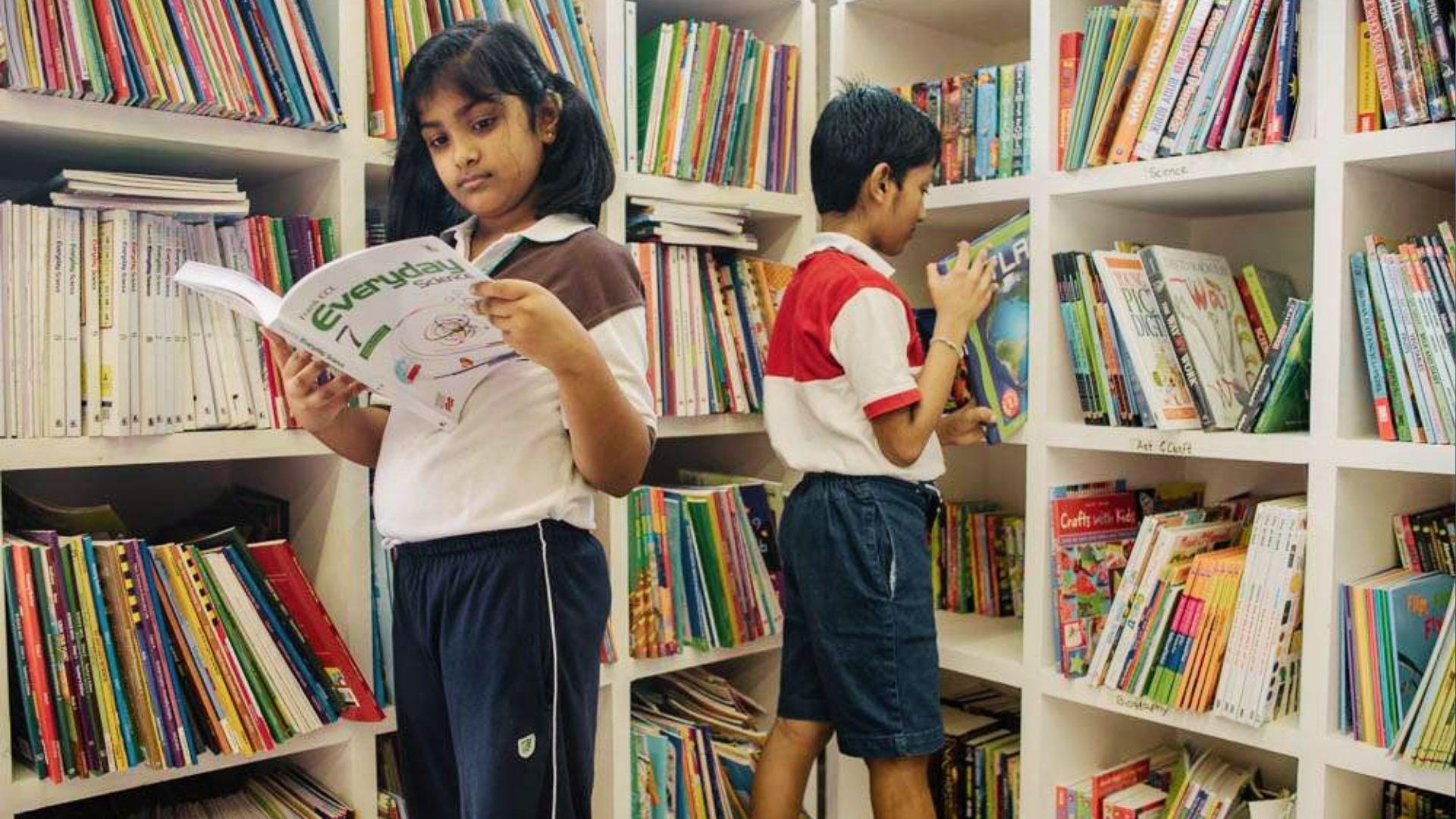 Middle school students browse books in library shelves to research and build reading habits for better grades.