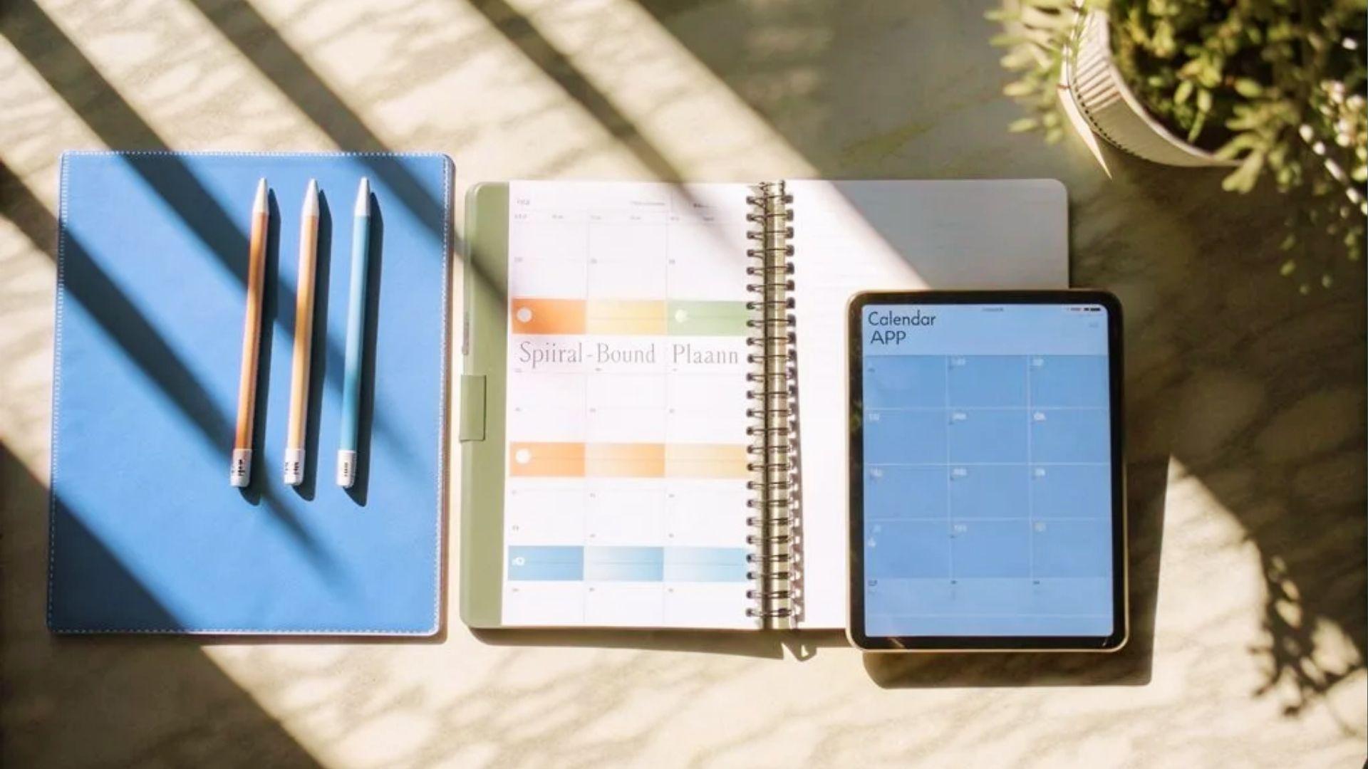 Desk with planner, tablet calendar app, and pens showing tools for organizing school schedules.