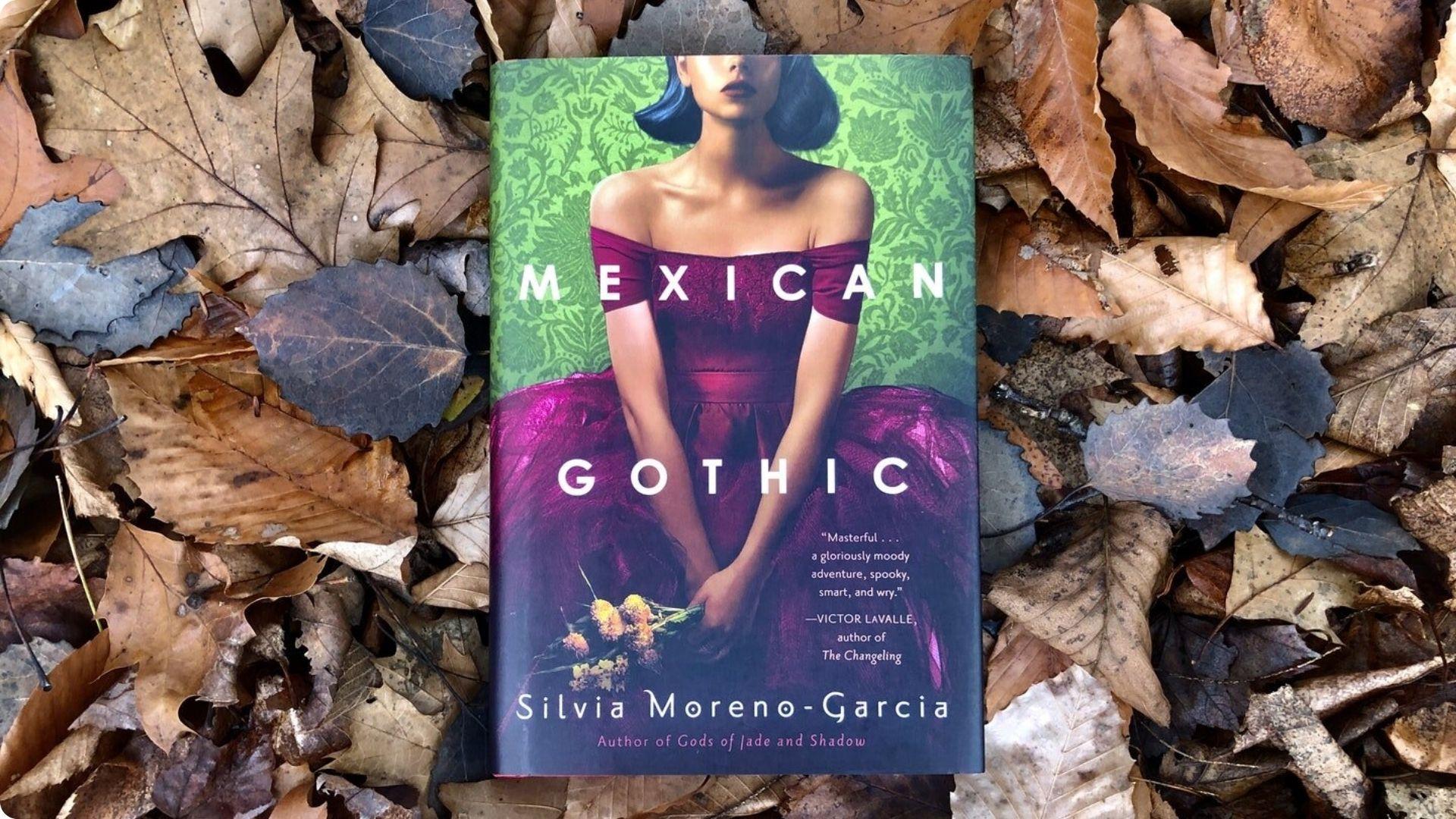 "Mexican Gothic" by Silvia Moreno-Garcia resting on autumn leaves, a NYT bestselling gothic novel.