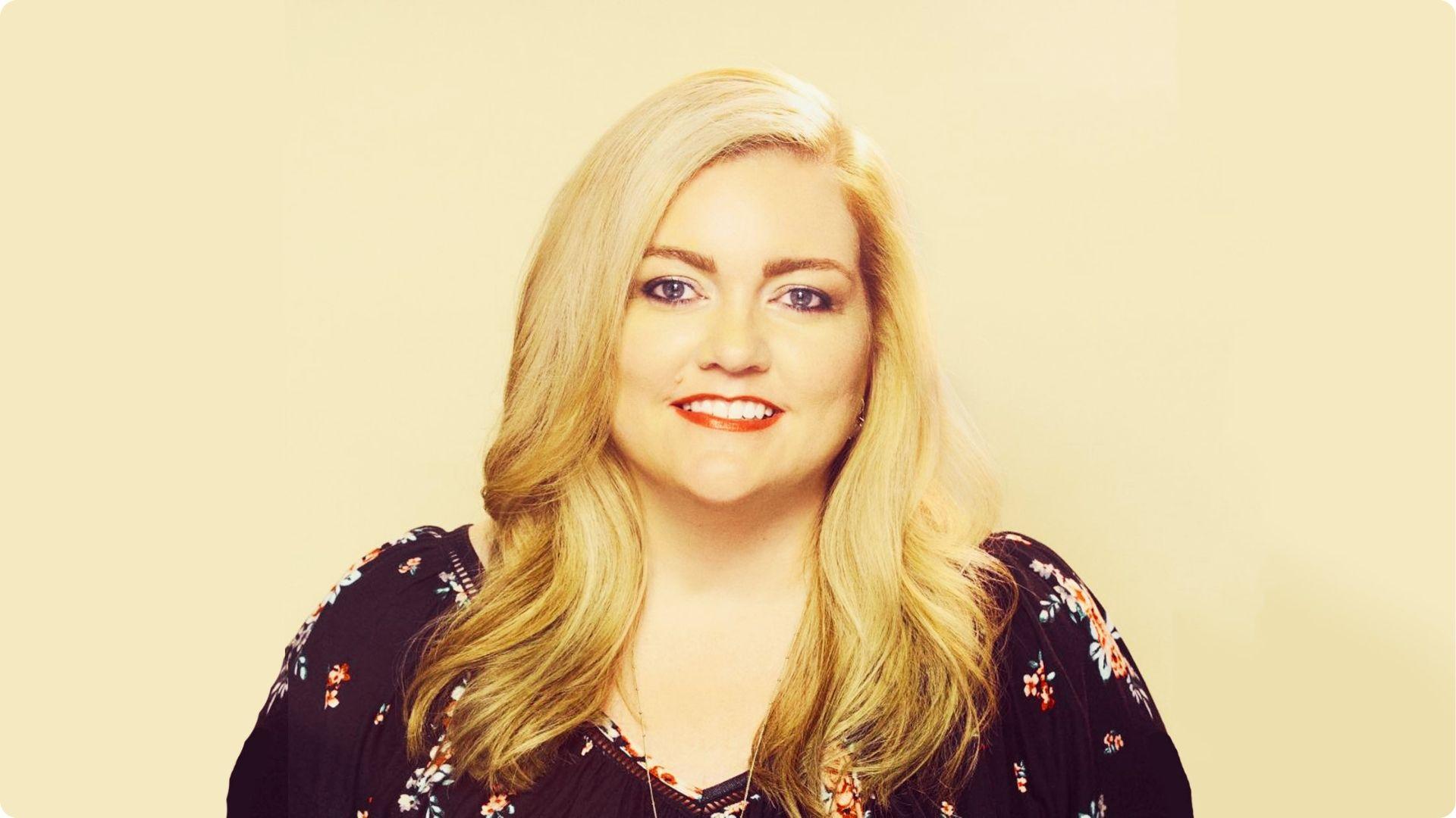 Colleen Hoover in blue dress smiling for the camera.