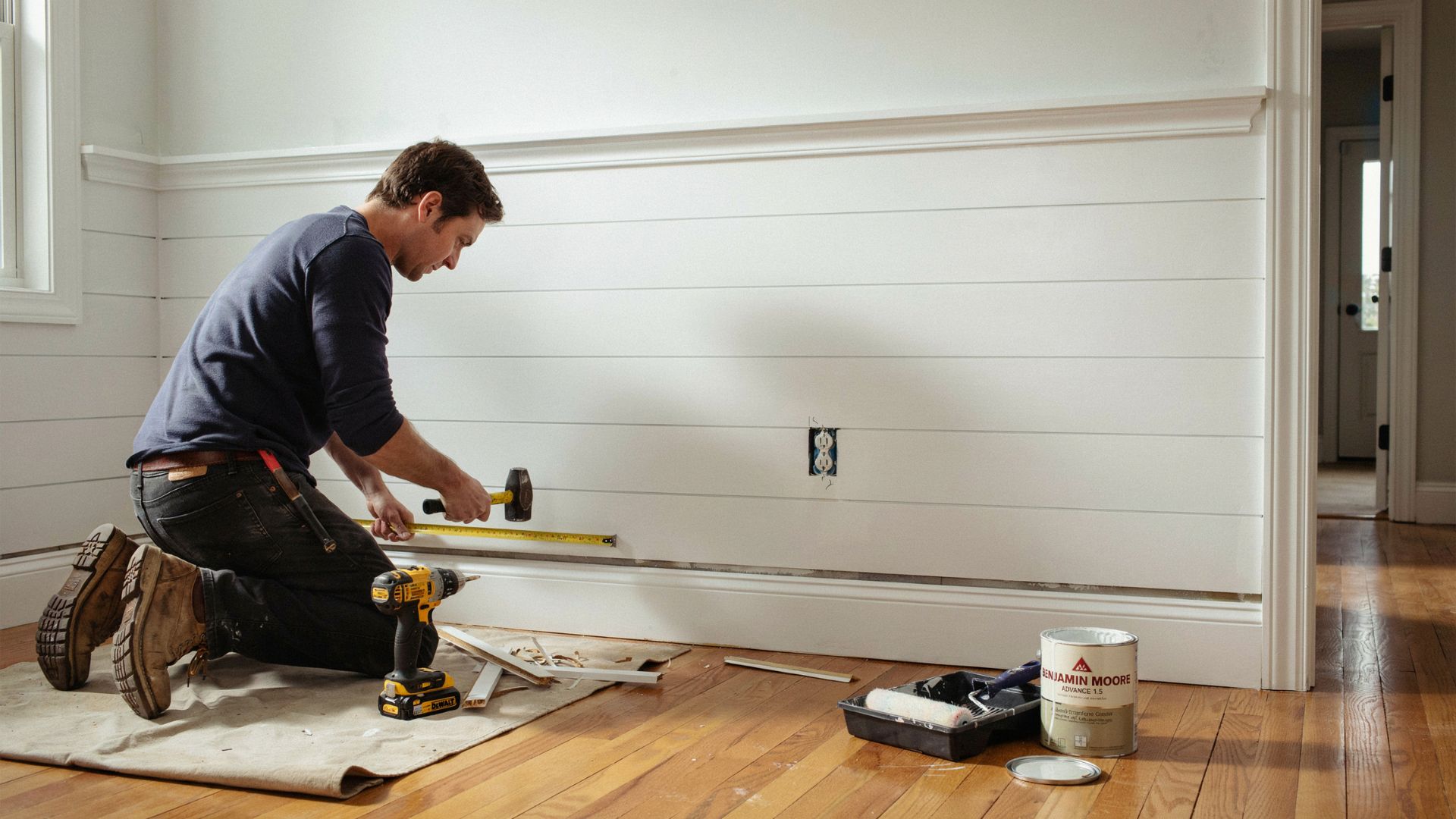Installing trim and baseboards on a shiplap accent wall.