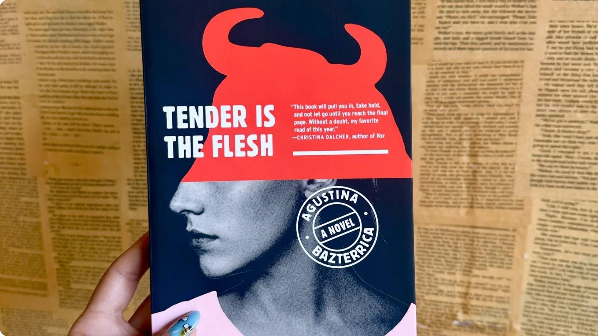 Hand holding "Tender Is the Flesh" by Agustina Bazterrica, a dark dystopian novel.