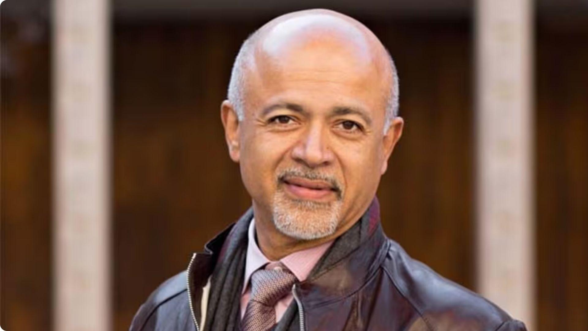 The author with a goatee in leather jacket and tie, smiling at camera outdoors.